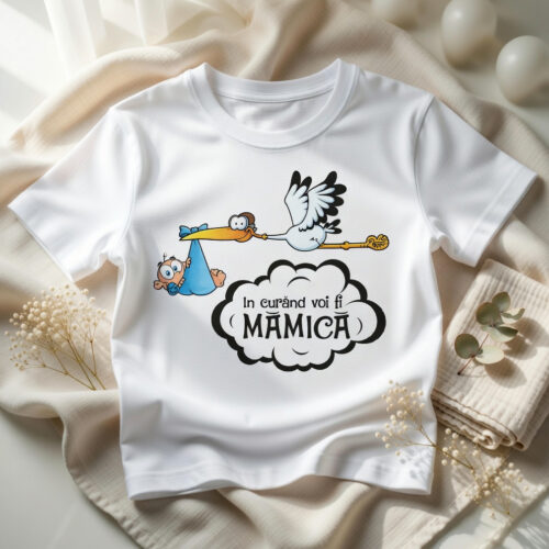 design-tricou-in-curand-voi-fi-mamica-flat design tricou alb „În curând voi fi mămică” cu barză simpatică ținând bebelușul, flat lay pe fond bej cu accesorii
